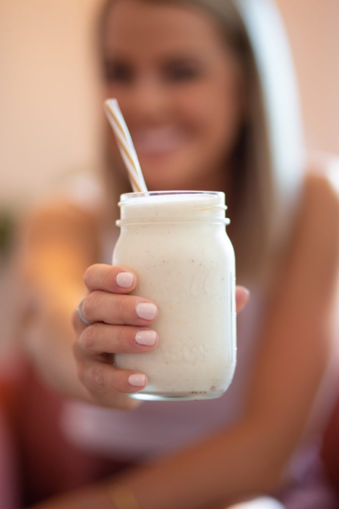 Frau hält Protein-Shake in der Hand.